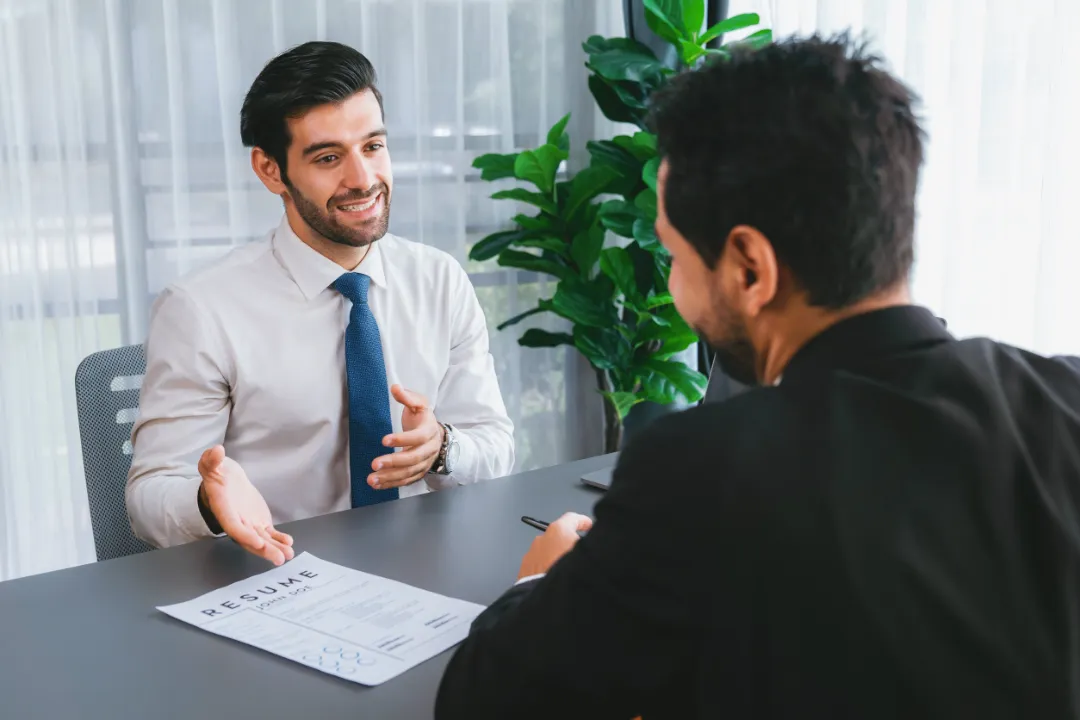 Interviewing job applicant in office with resume paper.
